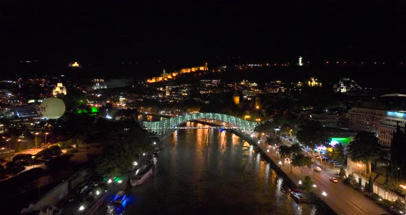 Night aerial view of Bridge of Peace and beautiful cityscape in the center of Tbilisi, Georgia 2022 alt