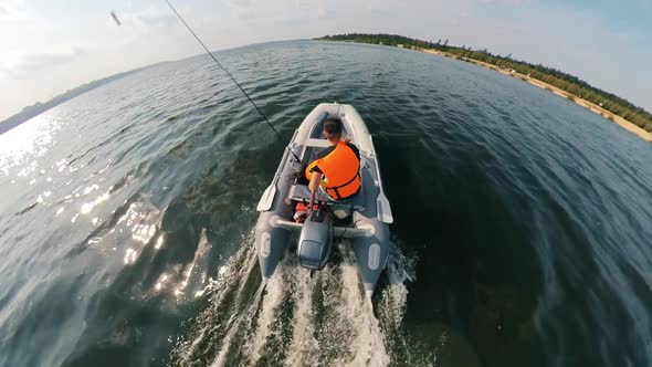 A Man in a Lifevest Is Onboard of the Motorboat alt