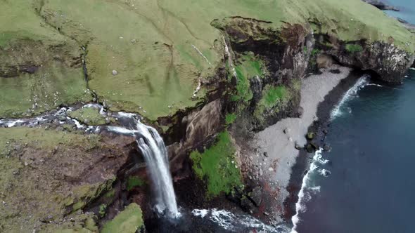 Tilting Camera To Waterfall To the Ocean in Faroe Islands