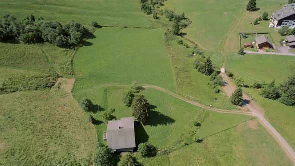 Aerial View of a Valley in Switzerland with Chalets and a Mountainous Landscape alt