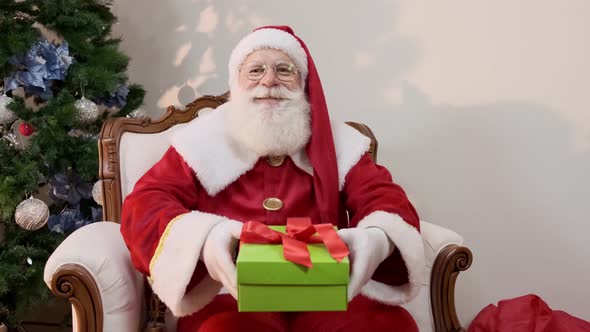 Santa Claus offering a gift to the camera. Receiving Christmas presents.