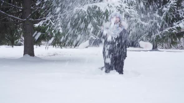 Teenage Girl Tosses Fresh Snow While Playing in Park alt