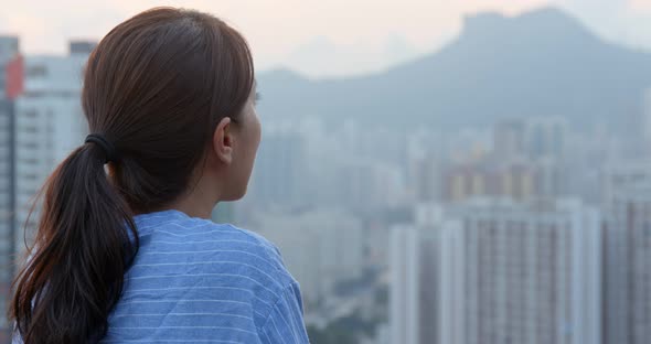 Woman look at the building and think in city of Hong Kong alt