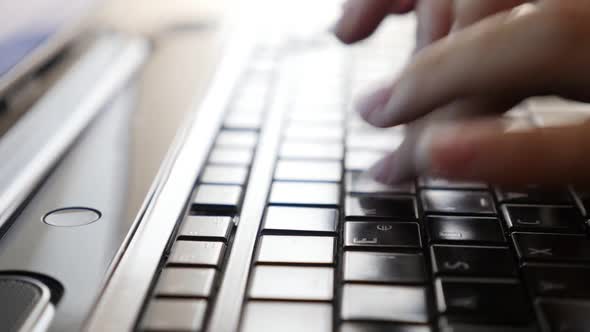 Modern business woman in office typing text on dark laptop keys close-up slow motion 1080p FullHD vi alt