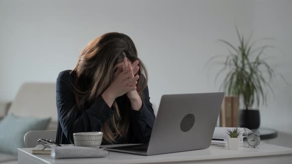 Pensive and serious young woman freelancer using laptop computer and  typing message alt