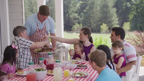 Group of people eating and enjoying a backyard barbeque