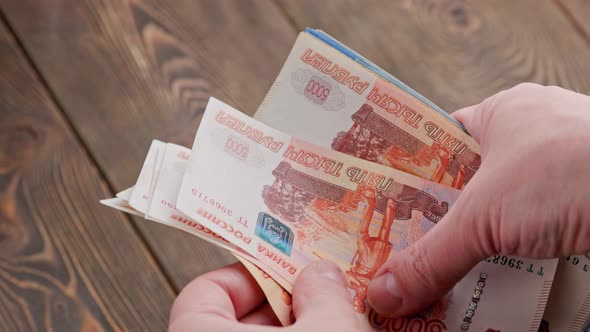 Caucasian Hand Counting Small Stack of Russian Ruble Banknotes