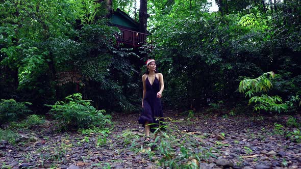 Cute Asian Girl Walking By a Treehouse Next to the River Thailand alt