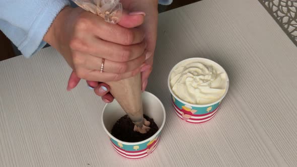 A Woman Makes Ice Cream With Cream And Biscuit Crumbs. alt