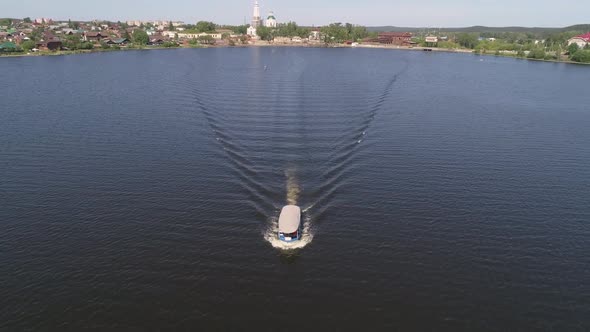 Aerial view of pleasure boat with people floats on the pond in provincial city 07 alt