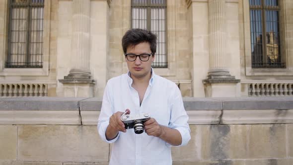 Handsome Artist in White Shirt Taking a Picture of Paris Architecture