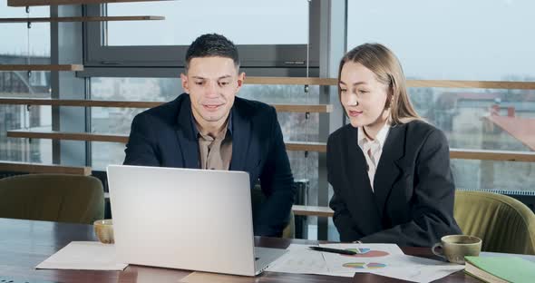 Man and a Woman Discussing Work in the Brightly Lit Modern Office, Concerned Male and Female Working