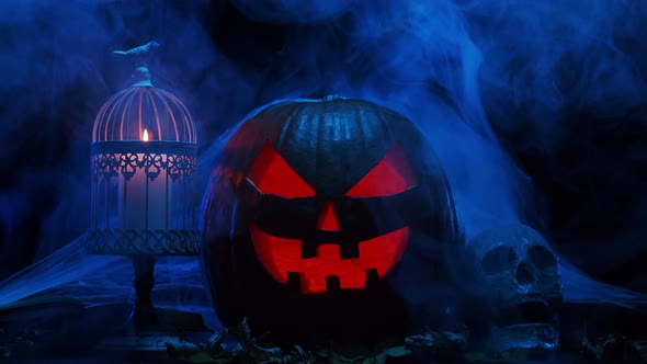 Scary laughing pumpkin and an old skull over the frightening gothic background. alt