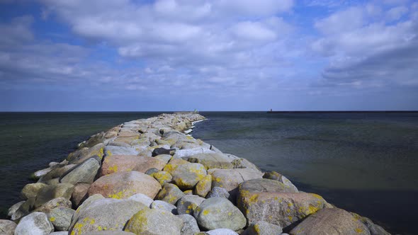 Old pier made of stones in the Baltic Sea in spring