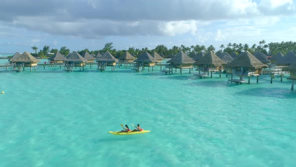 Aerial drone view of a man and woman couple on a tandem sea kayak in Bora Bora tropical island alt