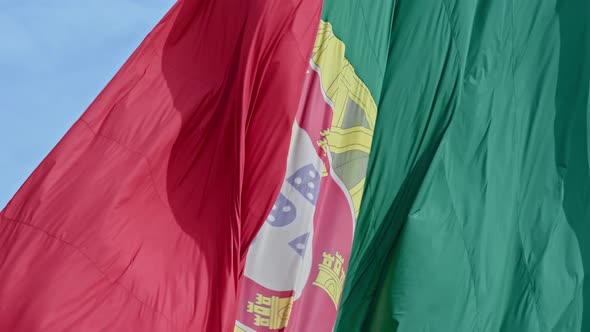 Closeup of National Flag of Portugal Waving in the Wind on Clear Sunny Day at Blue Sky