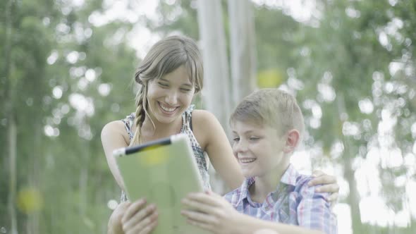 Mother and son using digital tablet outdoors