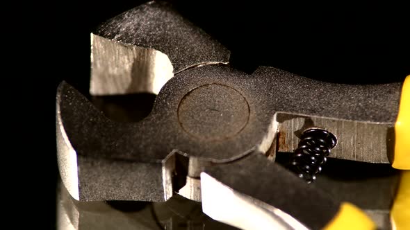 Part of Wire Cutters with Yellow, Gray Handle on Black, Reflection, Close Up, Rotation alt