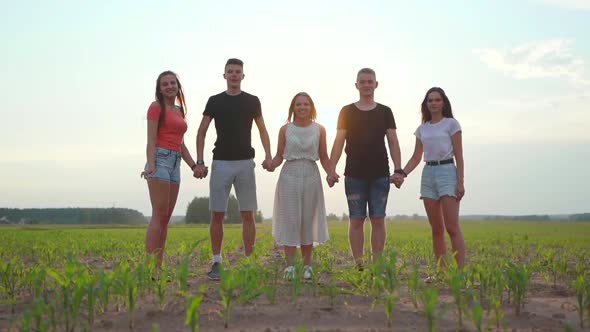 Five Happy Friends Jumping Holding Hands at Sunset. Slow Motion Video. Slow Motion Video. alt