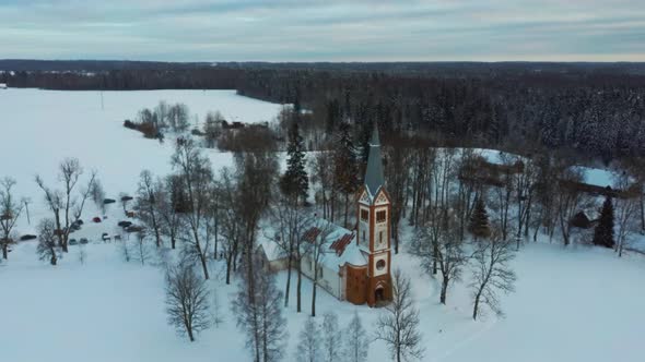 Aerial Top View of the Krimulda Evangelic Lutheran Church in Winter at Sunrise Latvia 4k Video alt