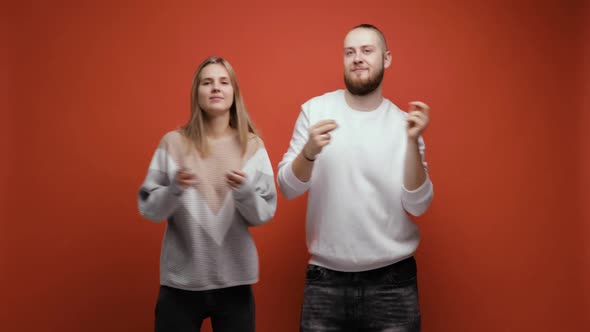 Young Couple Friends Bearded Man and Woman Dancing Together on Red Background