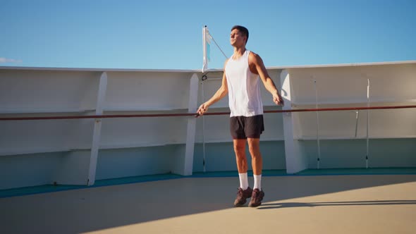 Athletic Young Man Jumping Rope Outside on Cruise Ship Open Deck