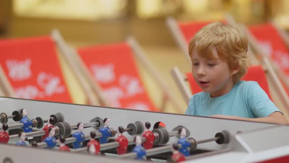 Blonde Young Boy Playing With Passion Table Football