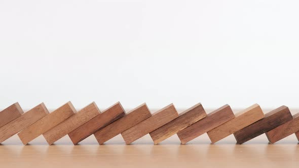 Domino effect made up from wooden blocks shape toy on wooden desk