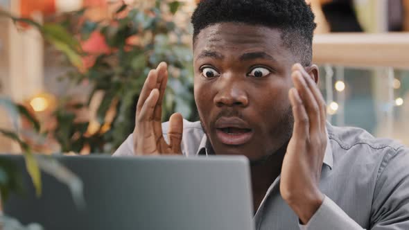 Closeup Young Businessman Looking at Laptop Screen Getting Bad News Surprised Shocked Man Holding alt