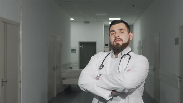 Confident Young Male Doctor Smiling To the Camera at Hospital Hallway