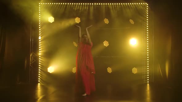A Young Girl Dancer in a Red Sari, Indian Folk Dance, Shot in a Dark Studio with Smoke and Yellow alt
