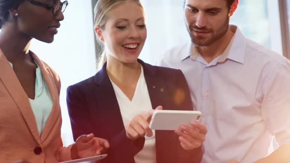 Businesspeople interacting over mobile phone alt