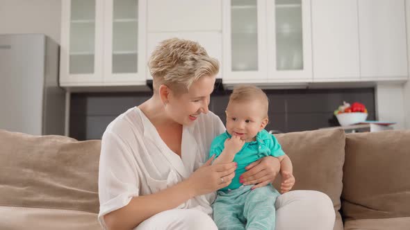 Mother Having Video Call While Sitting with Sons on Sofa alt