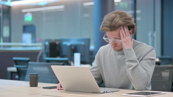 Young Businessman with Laptop Having Headache alt