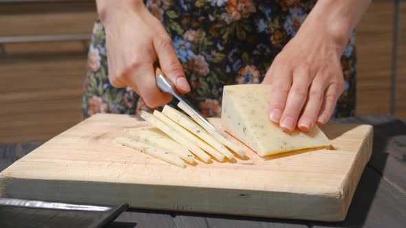 Closeup View Of Slicing Cheese With Herbs