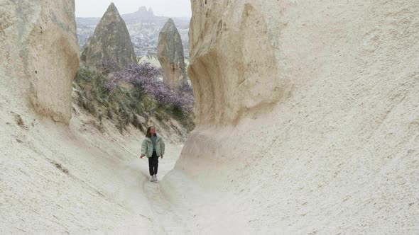 Happy Teenage Girl Hiking Through Canyon Among Rock Formations Enjoying Amazing Walking
