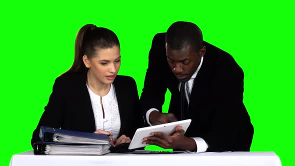 Two Businessman Discussing Documents on Laptop. Green Screen alt