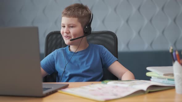 smiling student boy studying on the computer at remote school on the web alt