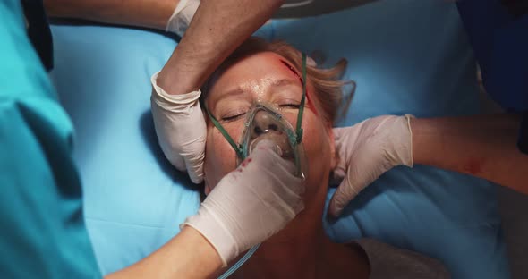 Close Up of Doctor Putting Mask on Unconscious Woman Patient alt