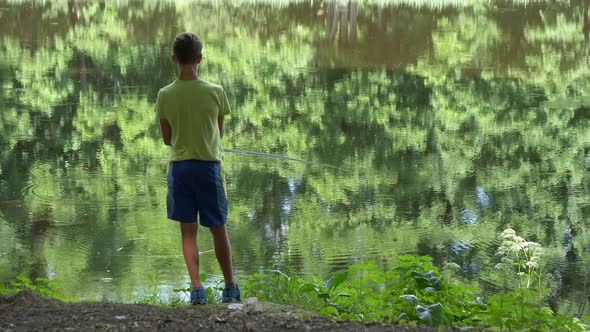 Teen Child Catches a Fishing Rod on The Pond