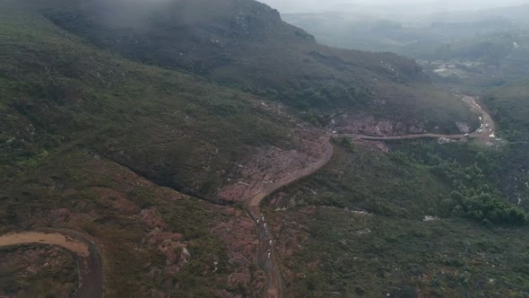 Aerial view of a group of horses across the road in the midle of the moutain. Minas gerais, Brazil. alt