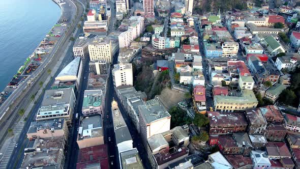 Aerial dolly out rising over Valparaiso hillside buildings and funicular in Cerro Concepcion near th alt