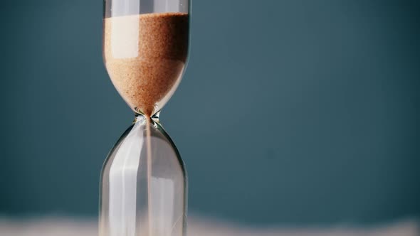 Countdown Hourglass Pouring on Blue Background alt