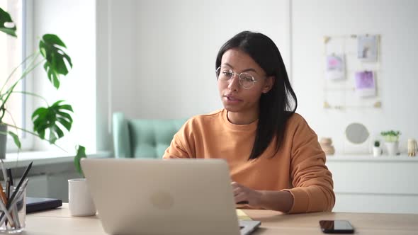 Woman with Glasses Leads a Video Meeting on Laptop in Home Interior Spbd alt