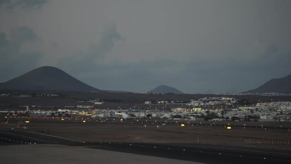 A Plane Taking Off the Runway Against the Evening Mountains alt