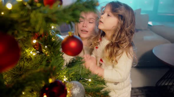 Two Sisters Helping Mother Decorating Christmas Tree alt