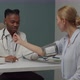 Male Doctor Examining Woman Patient By Checking Blood Pressure Indoors - VideoHive Item for Sale