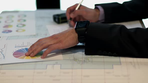 Businessman Works with the Drawings and Graphs alt
