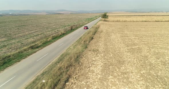 Car Driving On A Straight Road Plan Crops Partially Burned Winter Sunny Aerial Drone Shot