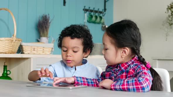 African Boy and Asian Girl Playing on Digital Tablet